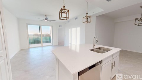 A kitchen with a marble countertop and a fan on the ceiling.