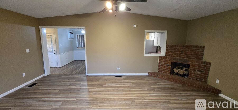 A living room with a fireplace and wood flooring.