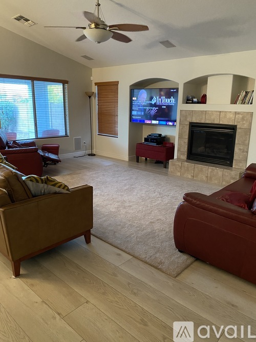 A living room with a fireplace and a television on the wall.