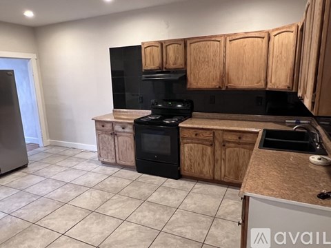 A kitchen with wooden cabinets and black appliances.