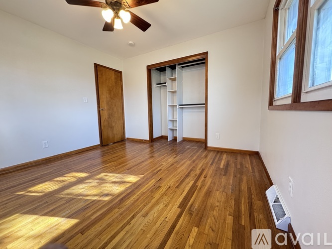 A room with wooden floors and a ceiling fan.
