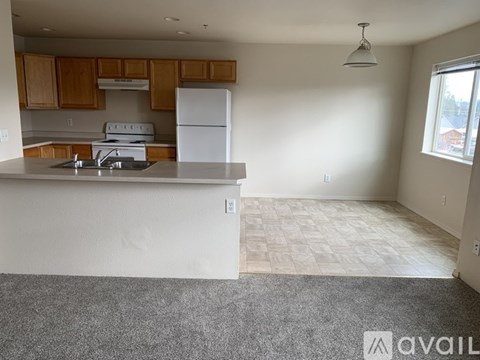 A kitchen with white appliances and wooden cabinets.