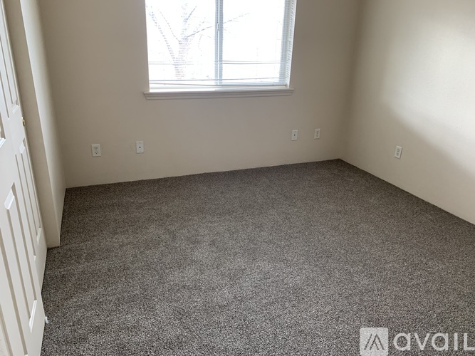 A room with a carpeted floor and a window.