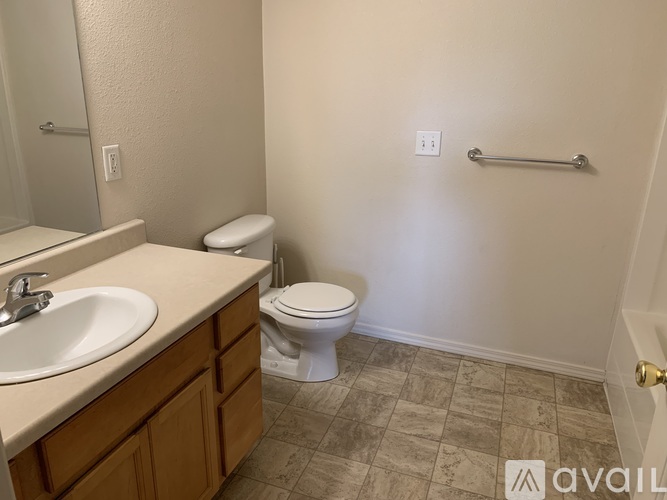 A bathroom with a toilet, sink, and tiled floor.