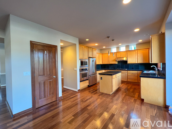 A kitchen with wooden floors and cabinets is available for rent.