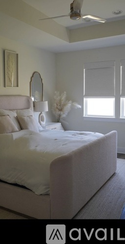 A bedroom with a large bed and a ceiling fan.