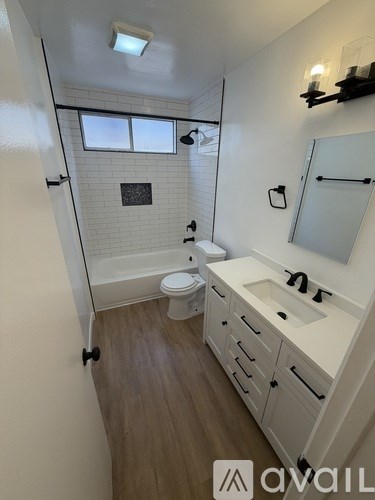 A white bathroom with a toilet, sink, and mirror.
