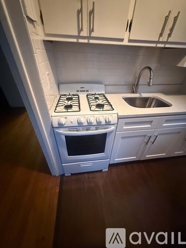 A white kitchen with a stove and sink.