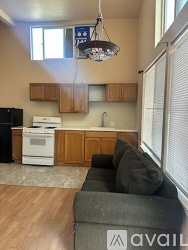 A kitchen with wooden cabinets and a black refrigerator.