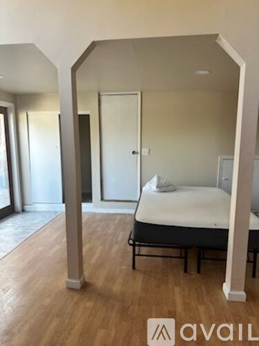 A bedroom with a bed and a mirrored doorway.