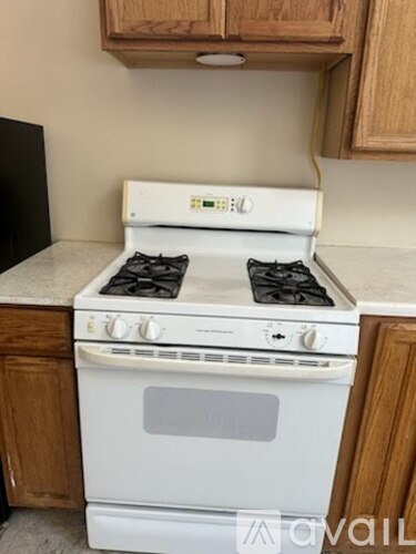 A white stove with a black pot on the stove.