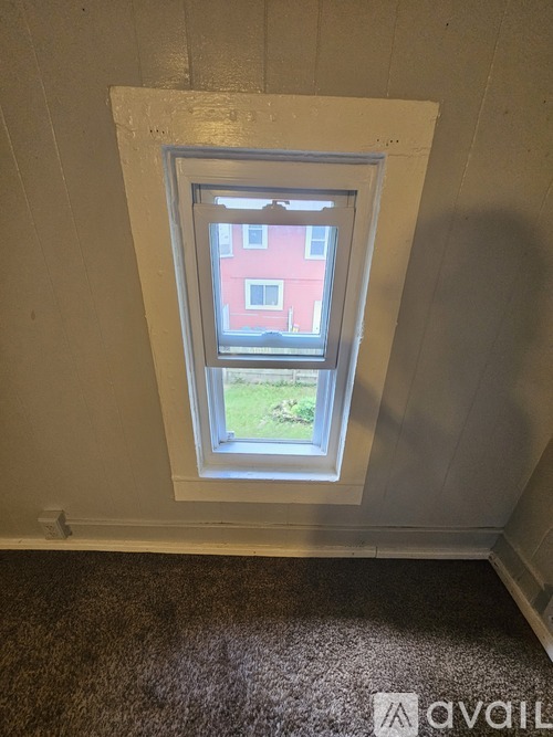 A window in a room with a carpeted floor.