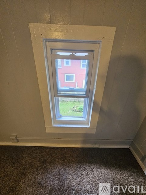 A window in a room with a carpeted floor.