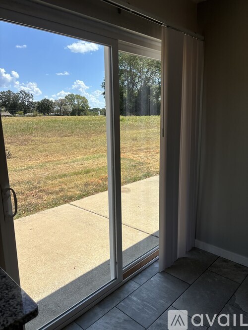 A view from inside a room looking out through a sliding glass door.
