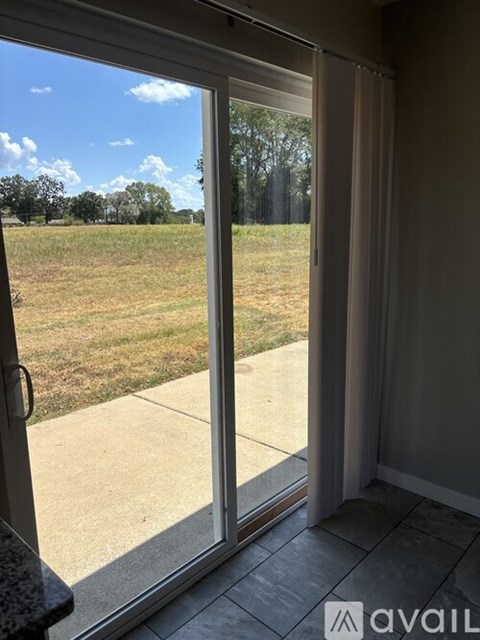A view from inside a room looking out through a sliding glass door.