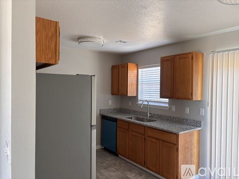 A kitchen with wooden cabinets and a granite countertop.