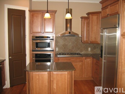 A kitchen with wooden cabinets and a granite countertop.