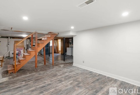 A wooden staircase with a railing leads to a second floor.