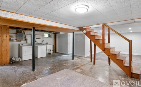 A room with a staircase and a kitchen area.
