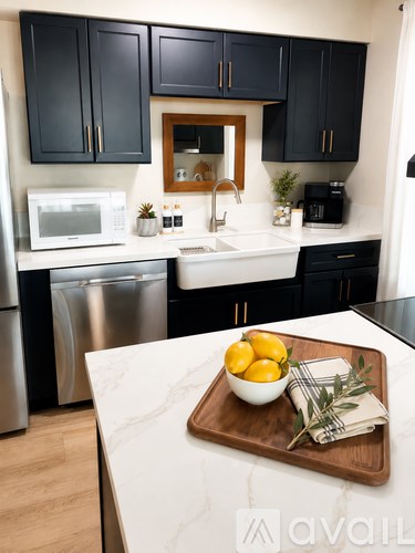 A kitchen with black cabinets and a white countertop.