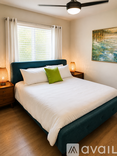 A bedroom with a large bed and a ceiling fan.