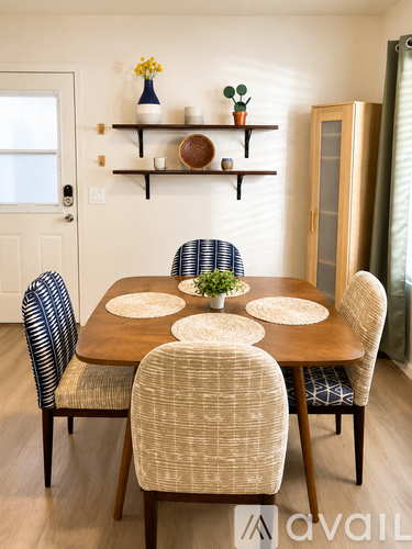 A dining room with a wooden table and chairs.