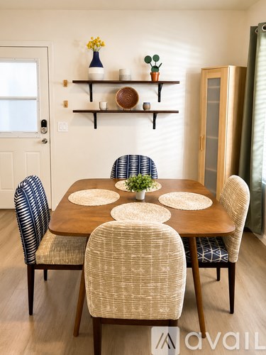 A dining room with a wooden table and chairs.