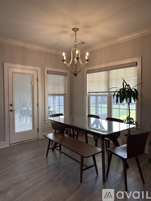A dining room with a table and chairs.