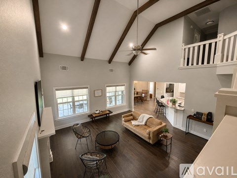 A spacious living room with a couch, chairs, and a television.