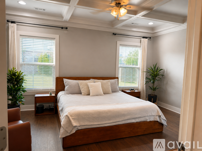 A bedroom with a large bed and a ceiling fan.