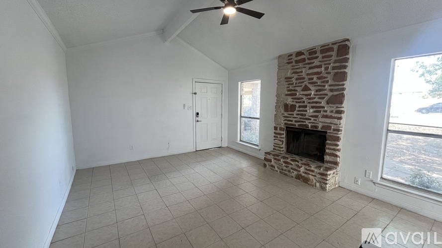A room with a fireplace and a ceiling fan.