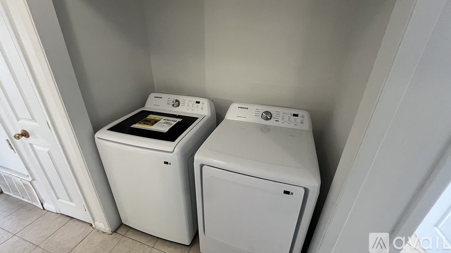 Two white front loading washing machines in a laundry room.