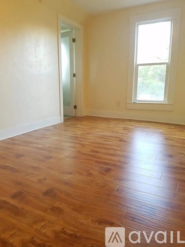 A room with wooden flooring and a window.