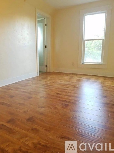 A room with wooden flooring and a window.