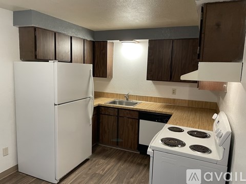 A kitchen with a white refrigerator and a white stove top oven.