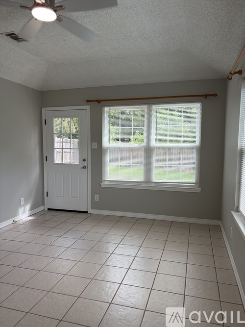 A room with a ceiling fan and tile flooring.