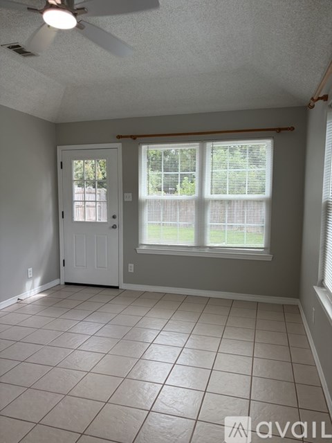 A room with a ceiling fan and tile flooring.