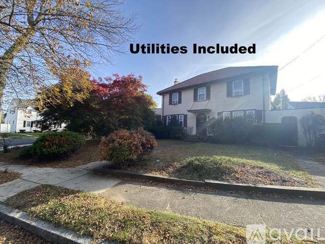 A house with a sign that says "Utilities Included" in front of it.