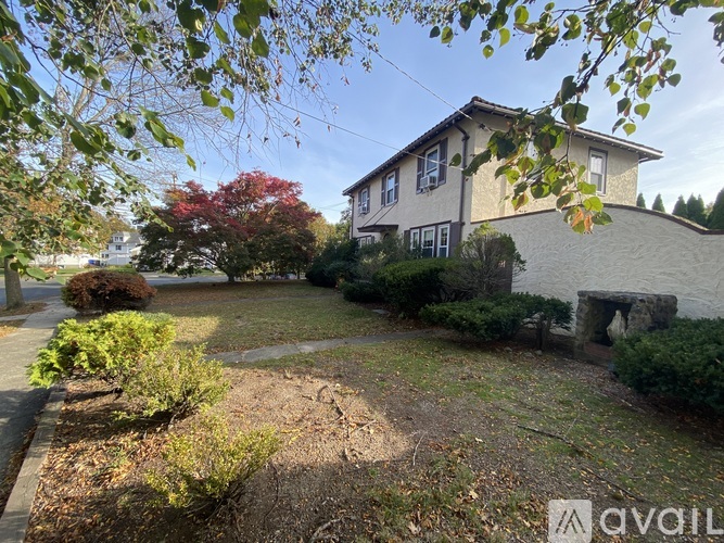 A house with a yard and trees in the background.