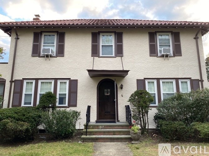 A house with a brown door and windows with shutters.