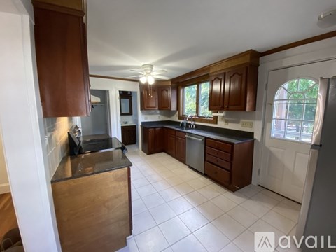 A kitchen with brown cabinets and a black countertop.