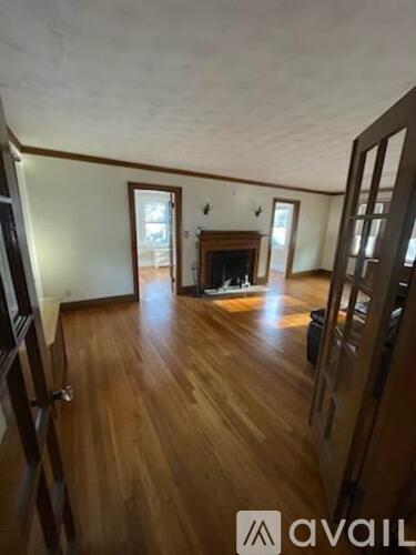A room with wooden floors and a fireplace.