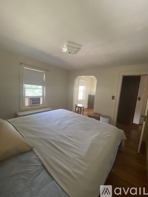 A bedroom with a large bed and a window.