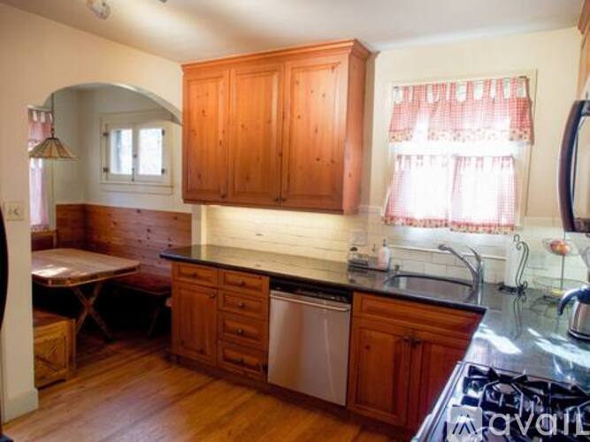 A kitchen with wooden cabinets and a black counter top.