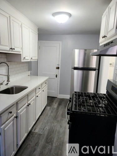 A kitchen with a sink, stove, and refrigerator.