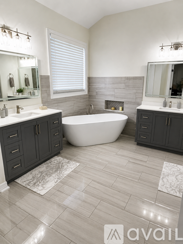 A modern bathroom with a large tub and double sinks.