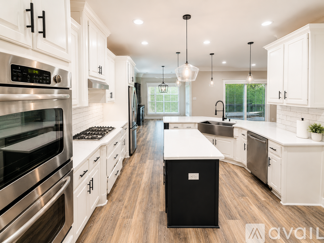 A modern kitchen with white cabinets and stainless steel appliances.