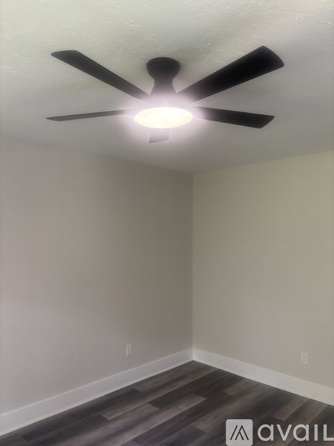 A room with a ceiling fan and light fixture.