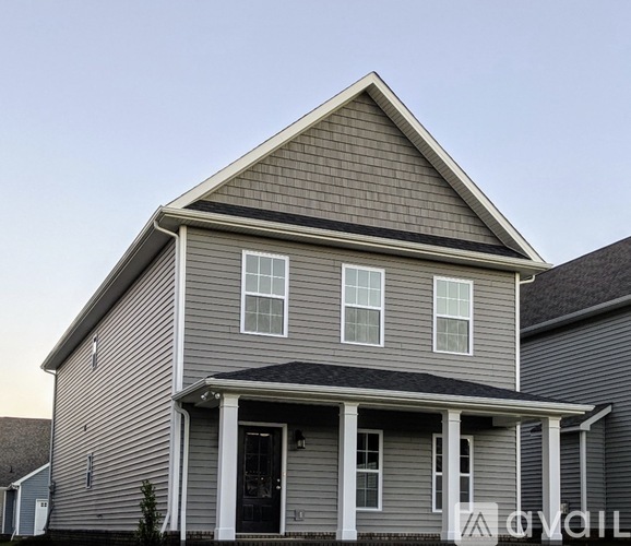 A house with a grey siding and white trim.