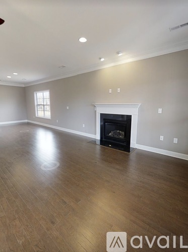 A spacious living room with a fireplace and hardwood floors.